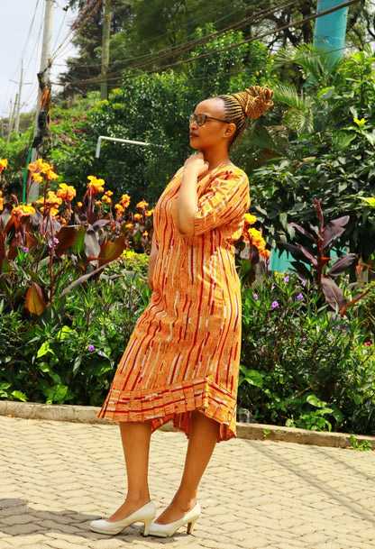 Dress of Orange, cream, red lines and dots motif.
