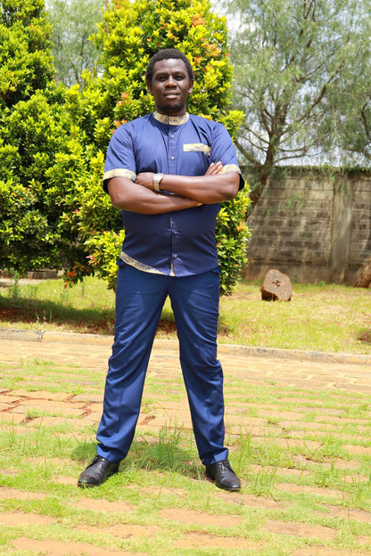 Man wearing a navy blue short-sleeve shirt and trousers set with traditional African print accents on collar and hem.